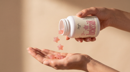 Verpackungsdesign für die Selfcare-Marke Grinsekatzen – Hände schütten rosafarbene, sternförmige Zuckerrausch-Fruchtgummis aus einer Dose mit individueller Illustration.